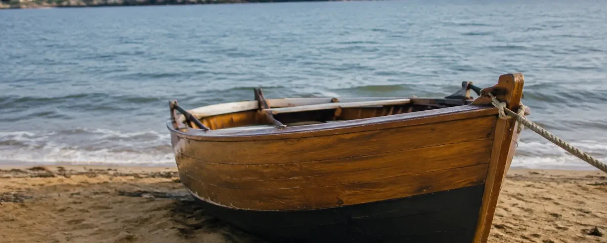 Barque en bois amarree sur plage de sable