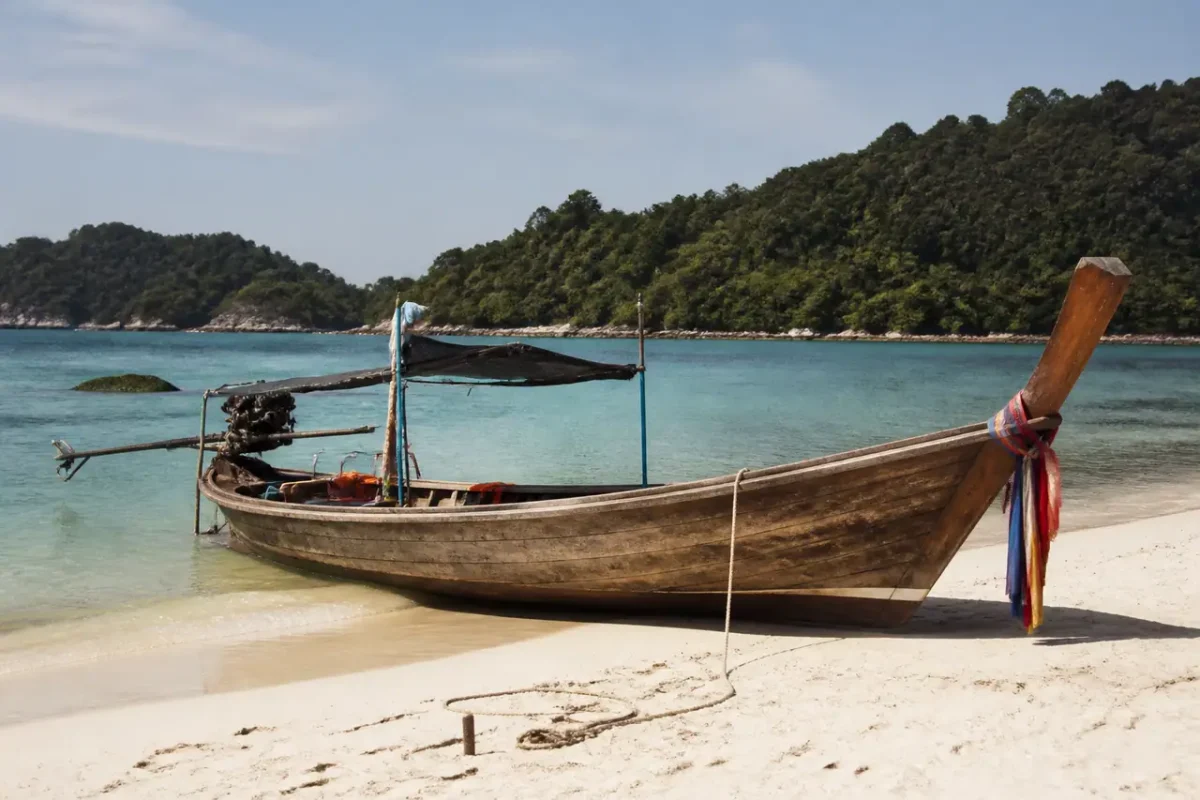 Bateau longtail en bois sur sable blanc