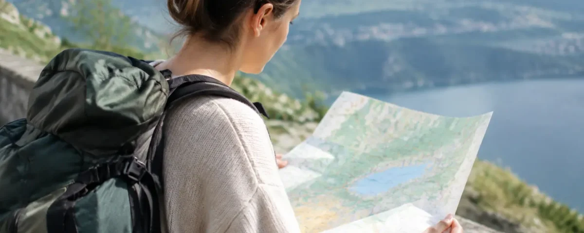 Voyageur avec sac a dos devant une carte coloree