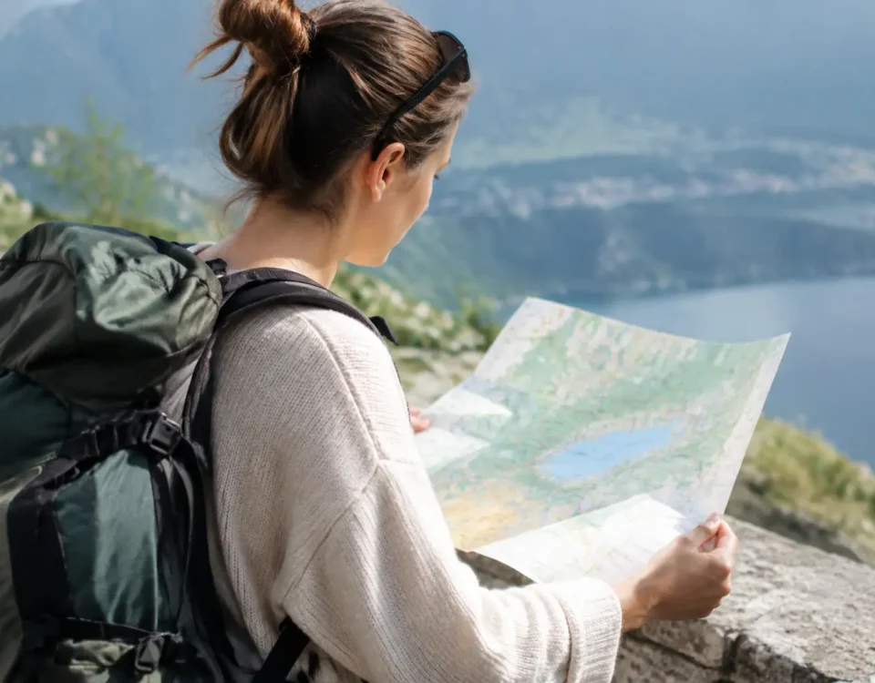 Voyageur avec sac a dos devant une carte coloree